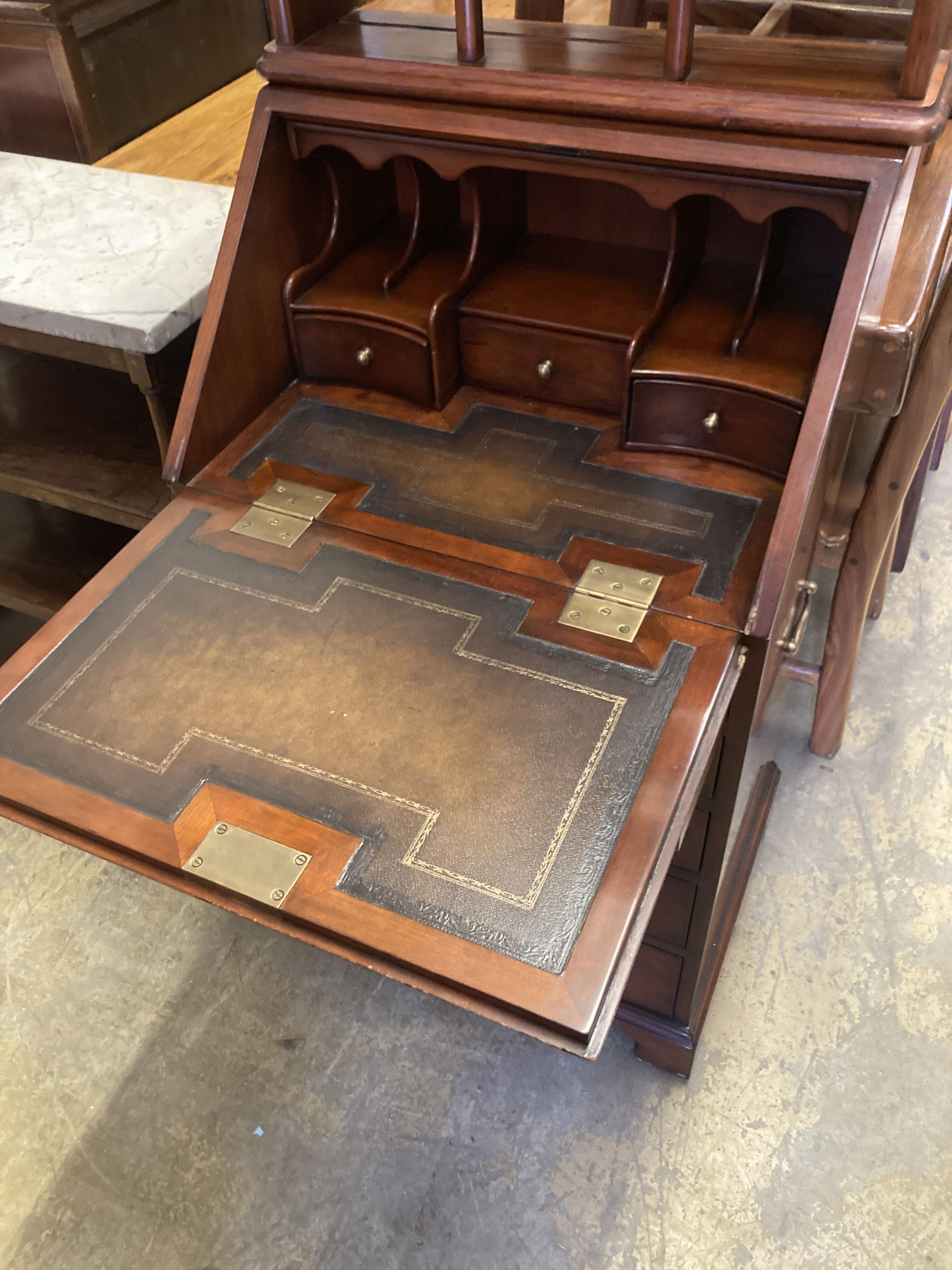 A small reproduction mahogany bureau, width 55cm, depth 43cm, height 102cm together with a three tier wall bracket